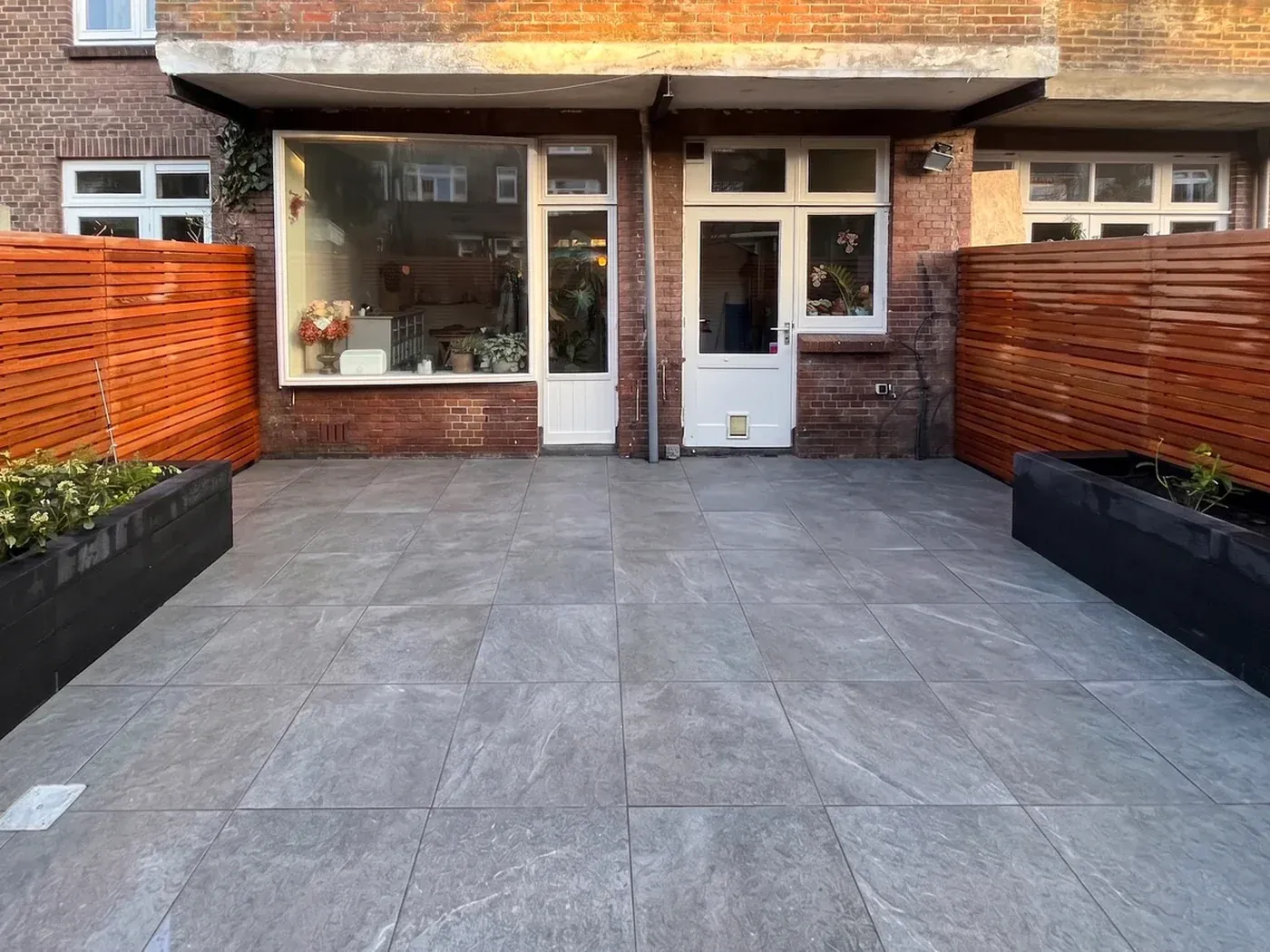 Terras met op maat gezaagde bestrating en hardhouten schutting in streeppatroon in de van Diepenburchstraat, Den Haag